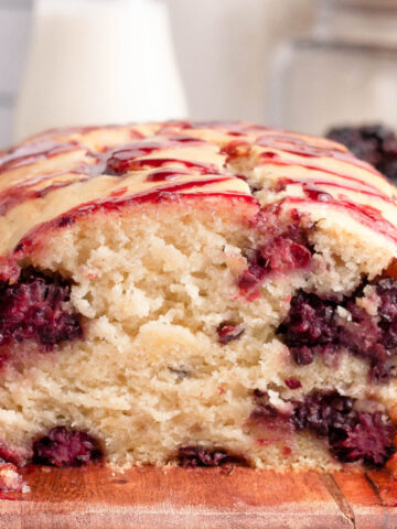 side image of sliced blackberry lemon bread on cutting board